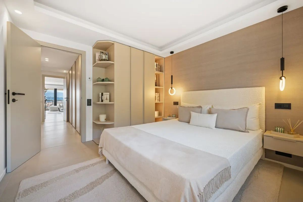 Chambre rénovée avec lit double, rangements intégrés et couloir ouvert sur le séjour, dans l'appartement Le Vert Boron